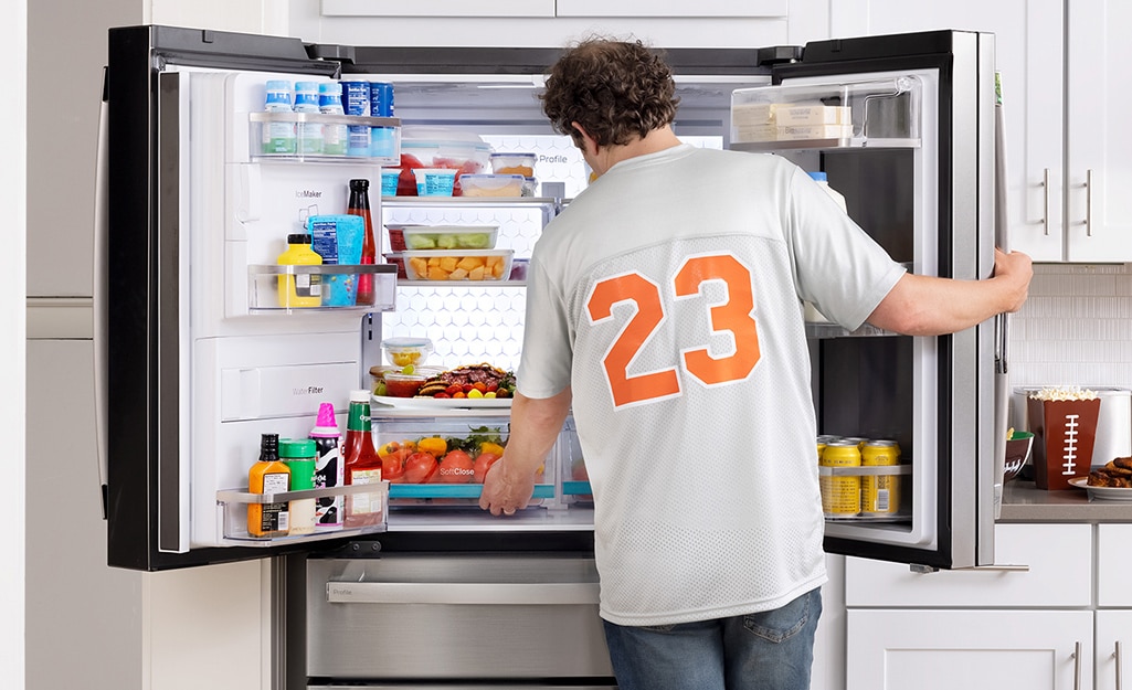 a man is taking food from the refrigerator