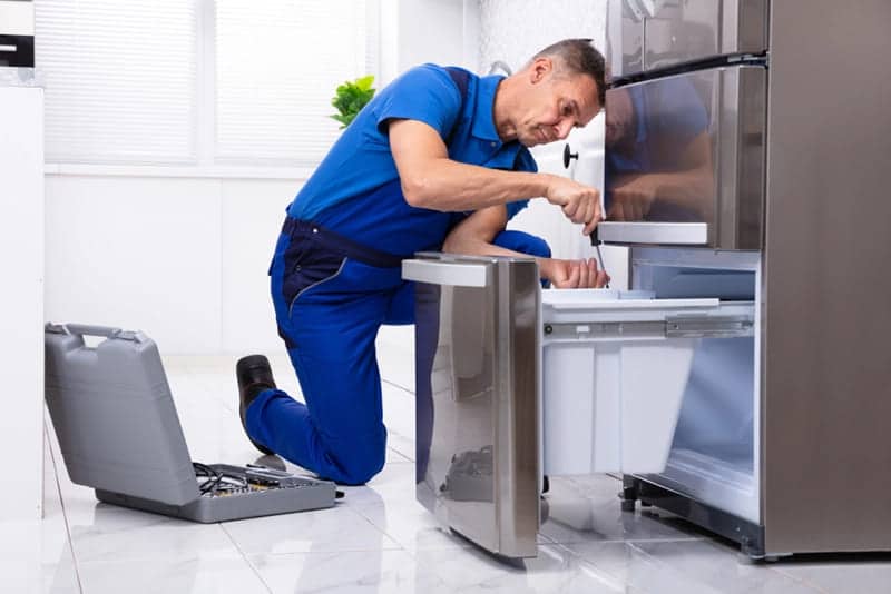 a technician fixing issues of refrigerator