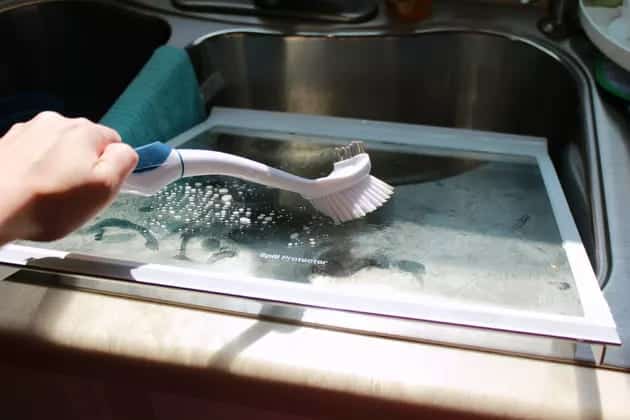 cleaning of inside of fridge with a brush 