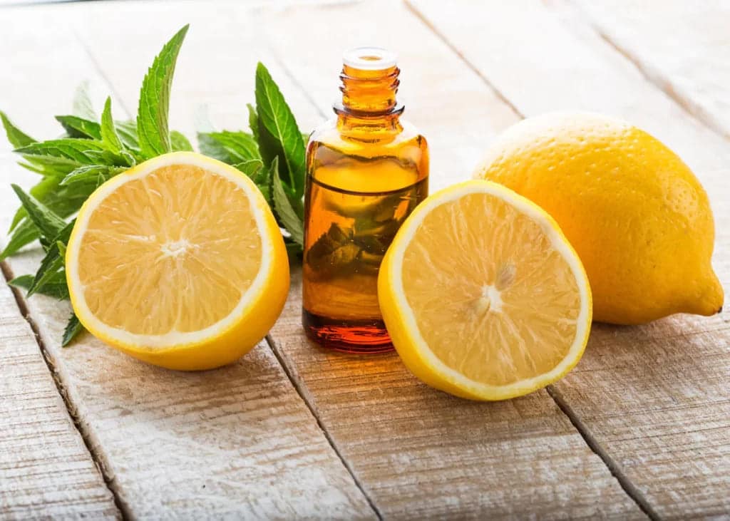 lemon essential oil bottle with mint and lemons