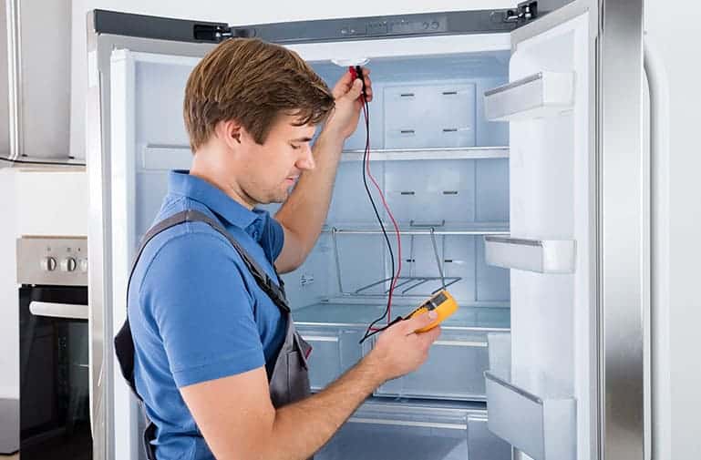 an expert checking the cooling performance of refrigerator