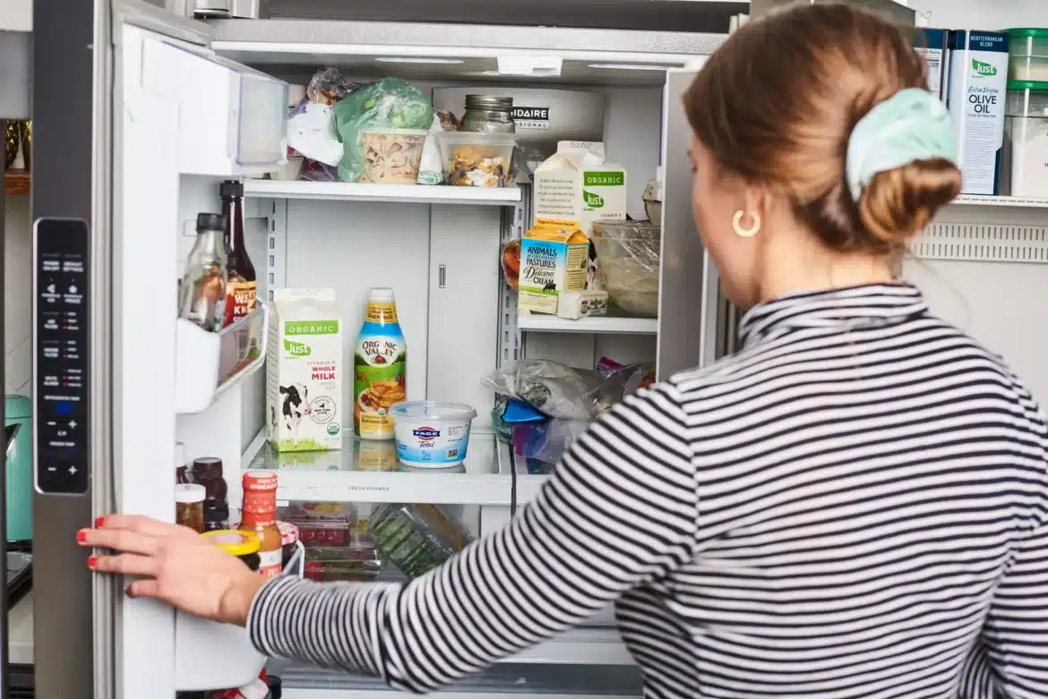 A backview of a woman with her fridge opened