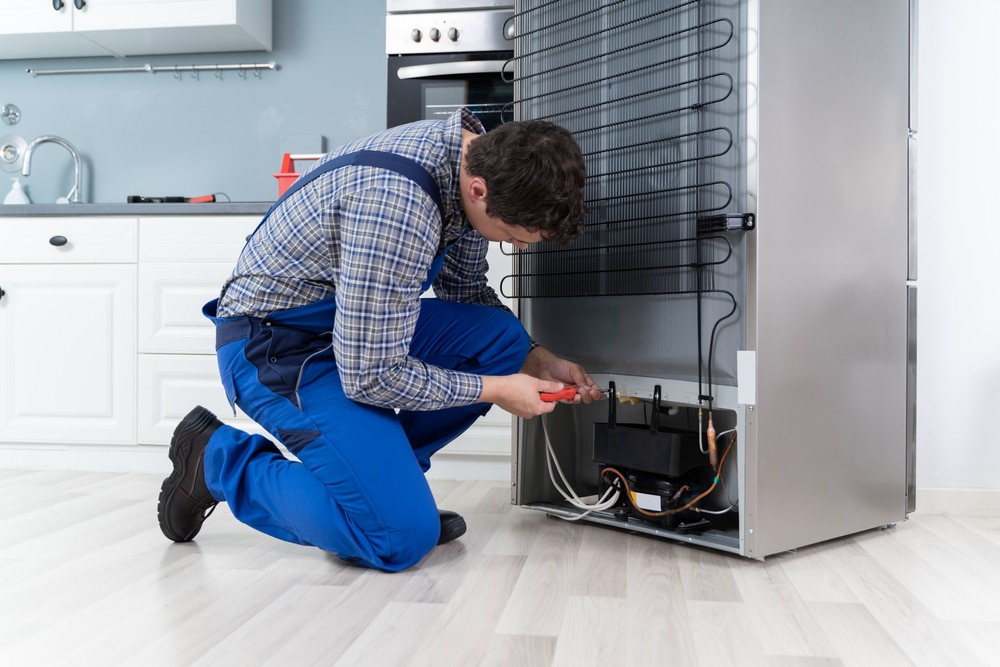 A view of a technician cleaning fixing condenser coils