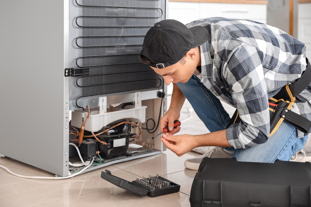 A view of a person fixing fridge