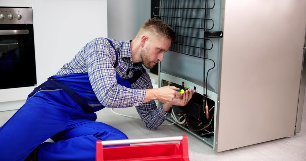 A view of a person repairing a fridge