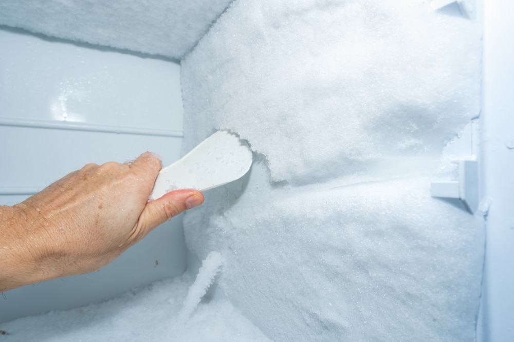 A view of a hand removing ice from the freezer