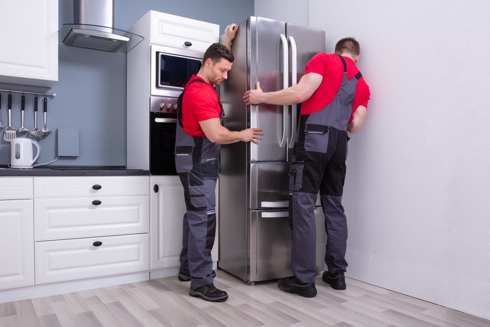 man moving the fridge for setup